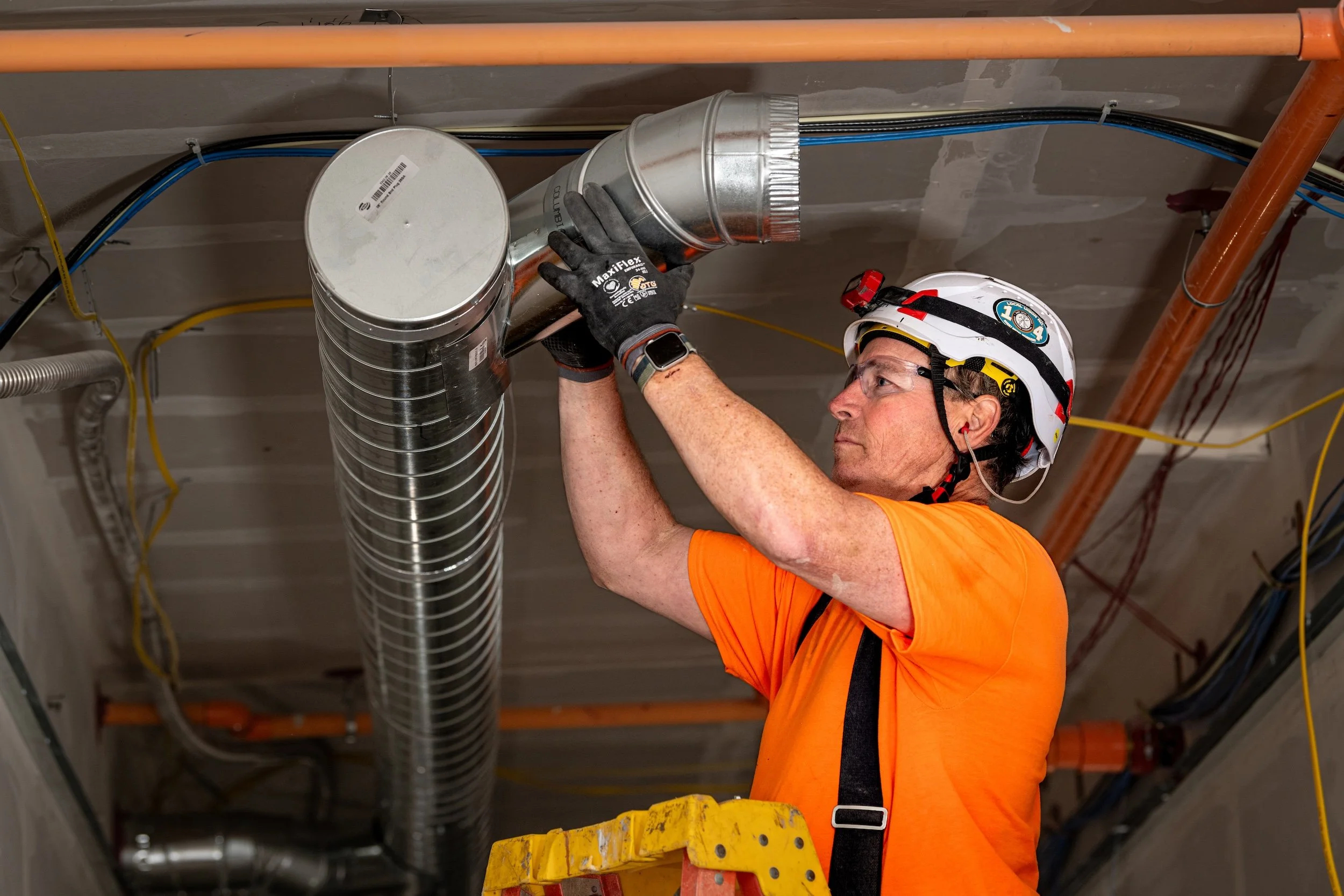 Technician installing commercial metal ventilation ductwork