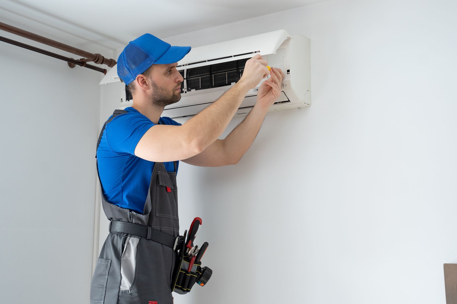 Technician inspecting the open front panel of an air conditioner